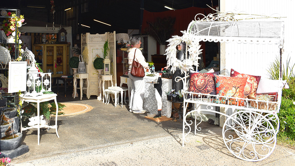 Photograph of the entrance to Trésor Maison with a customer inside talking to the shop owner.